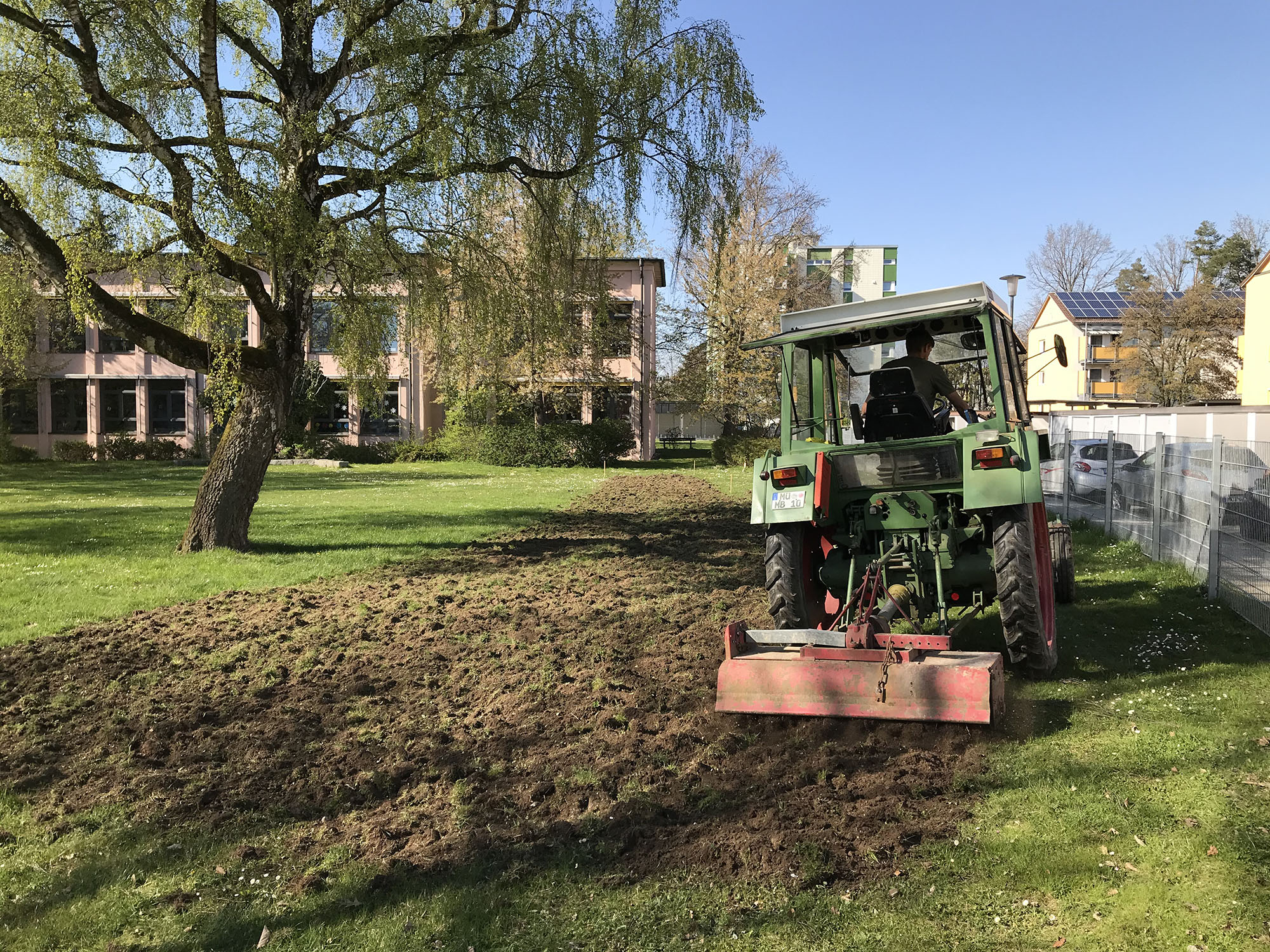 Ein Traktor bereitet den Boden für die Blumenwiese vor